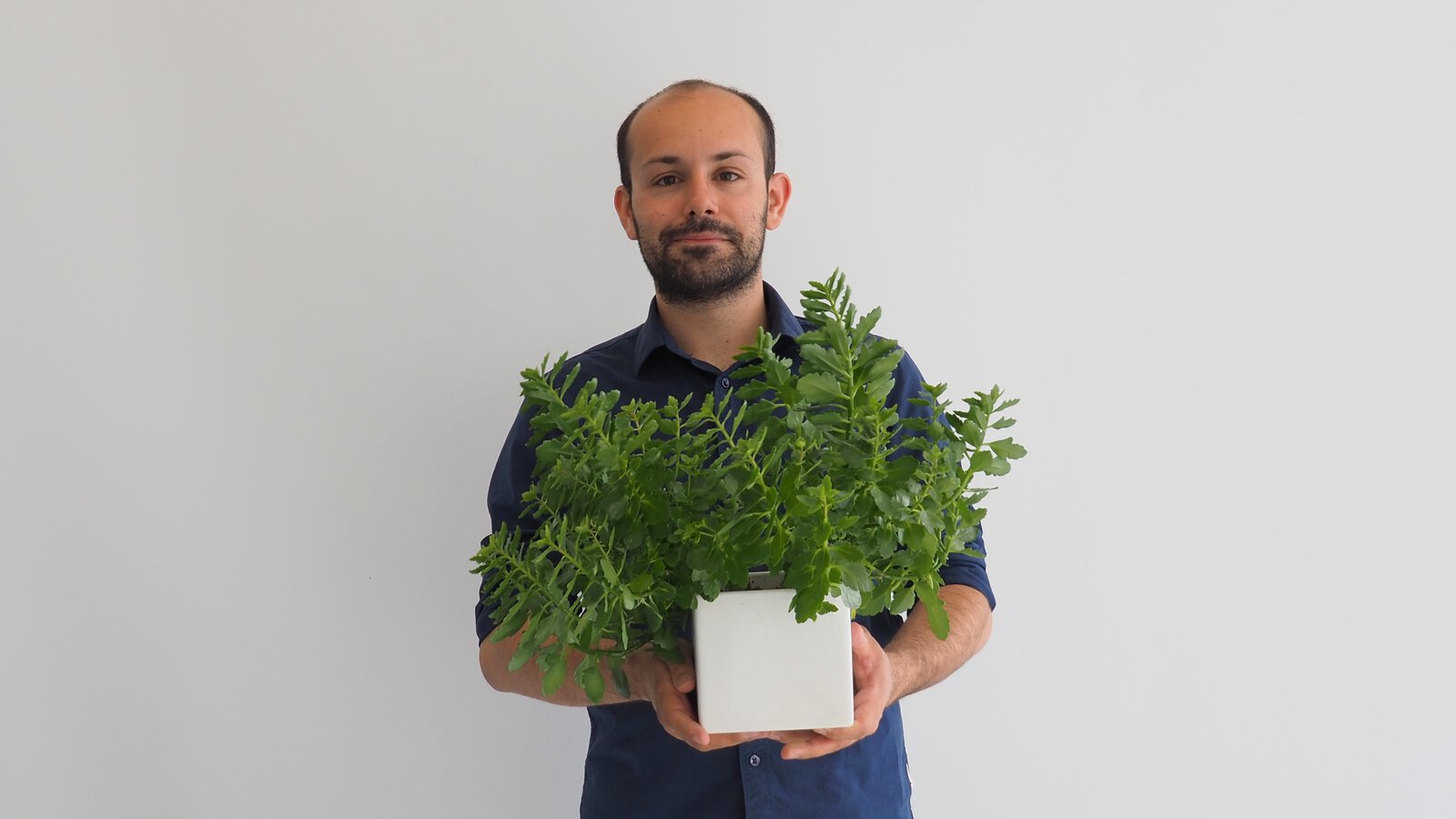 Studenten Alexander Sasa Bjelanovic holder en plante