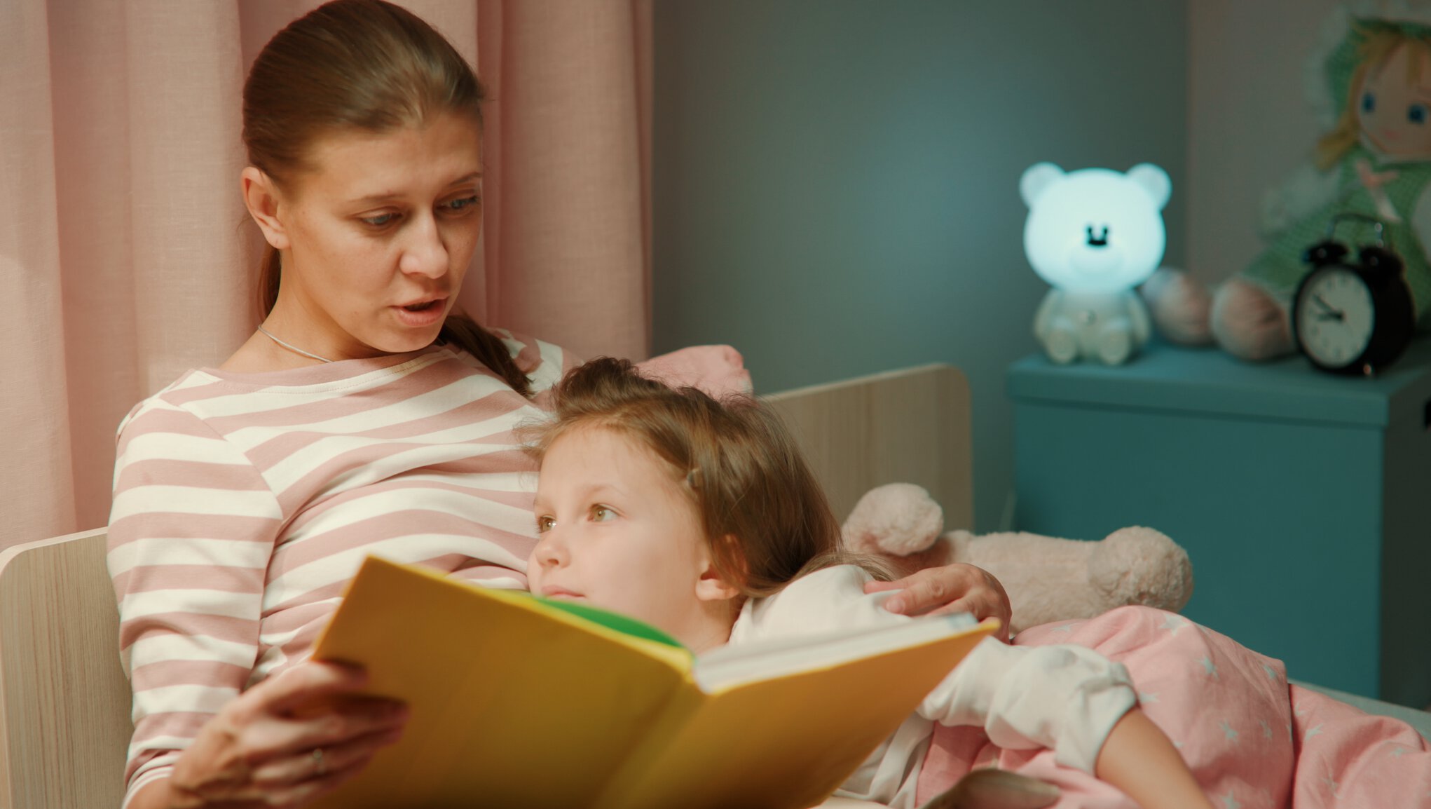 nainen lukee iltasatua lapselle
