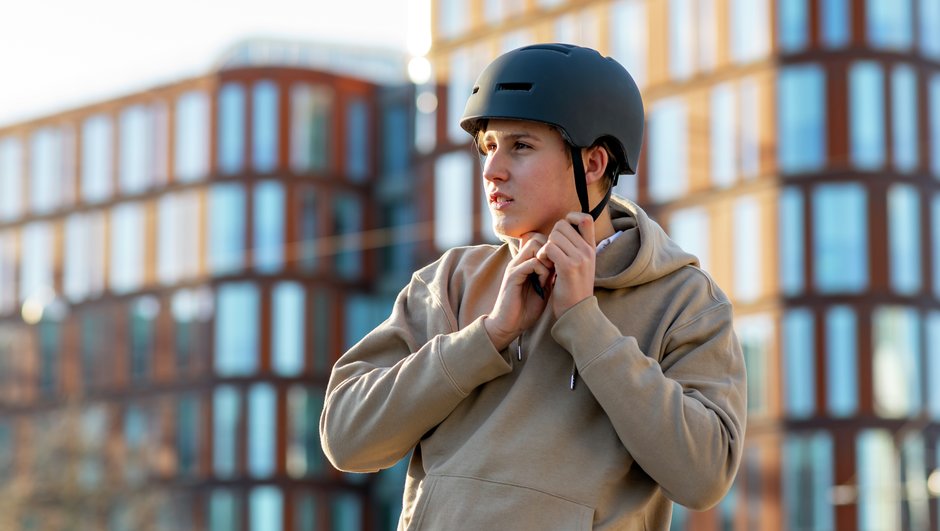 Tonåring sätter på sig cykelhjälm