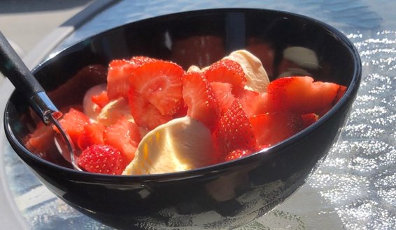Glassbord med en skål jordbær og vaniljeis