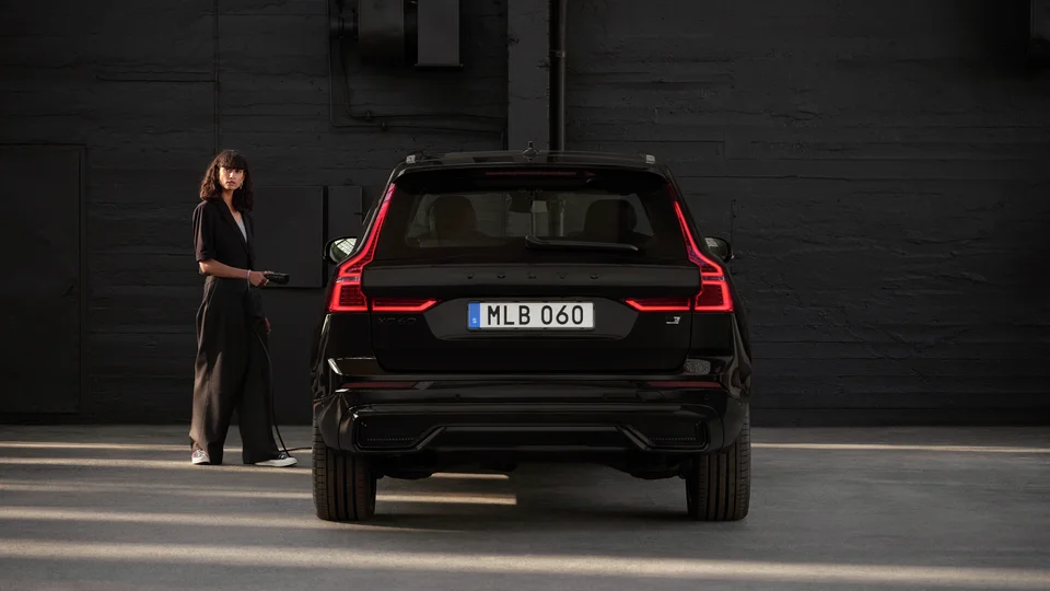 Kvinna i mörka kläder står bredvid en Volvo XC60.
