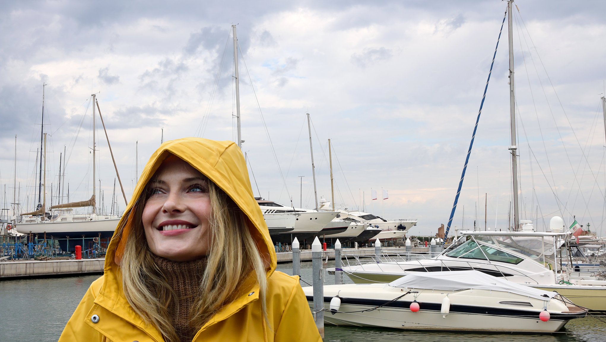 Jente med regnjakke på en båtbrygge