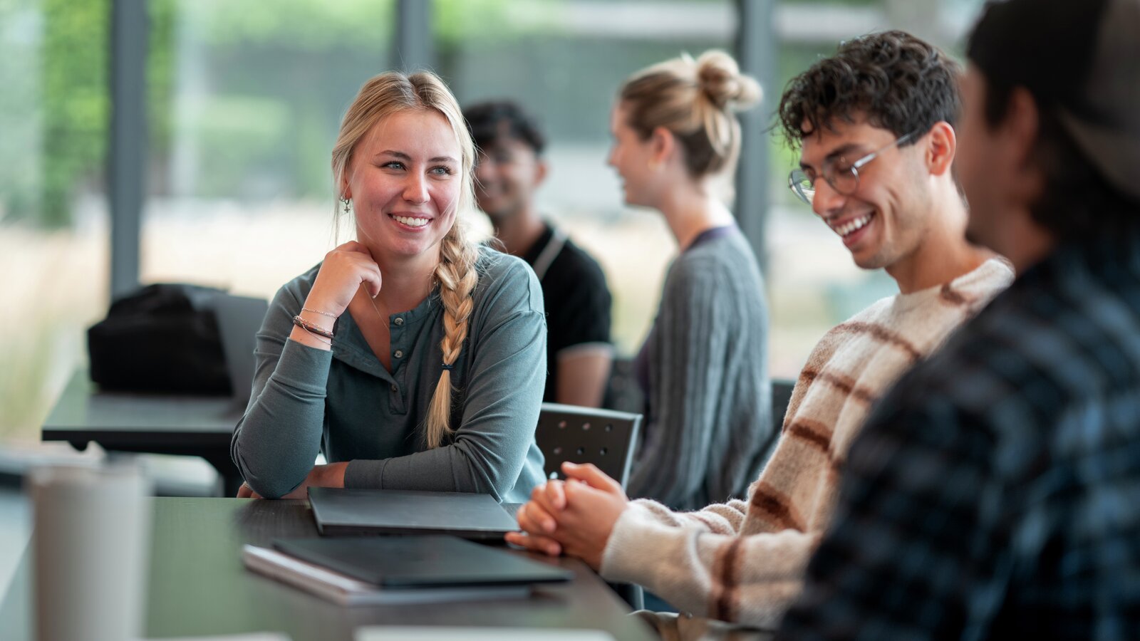 Gruppe av ulike studenter som deltar i en vennlig diskusjon i en lys klasse