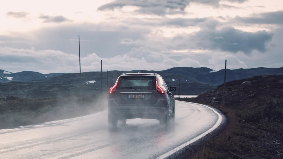 Volvo XC60 kör på blöt asfalt.