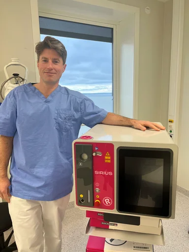Mannlig lege holder en rosa lasermaskin