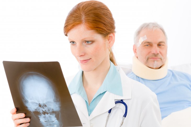 Lege studerer røntgenbilde til pasient