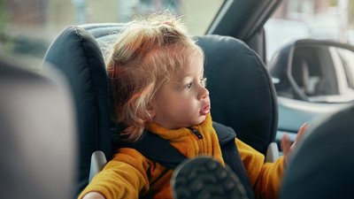 Vauva istuu auton lastenistuimessa 