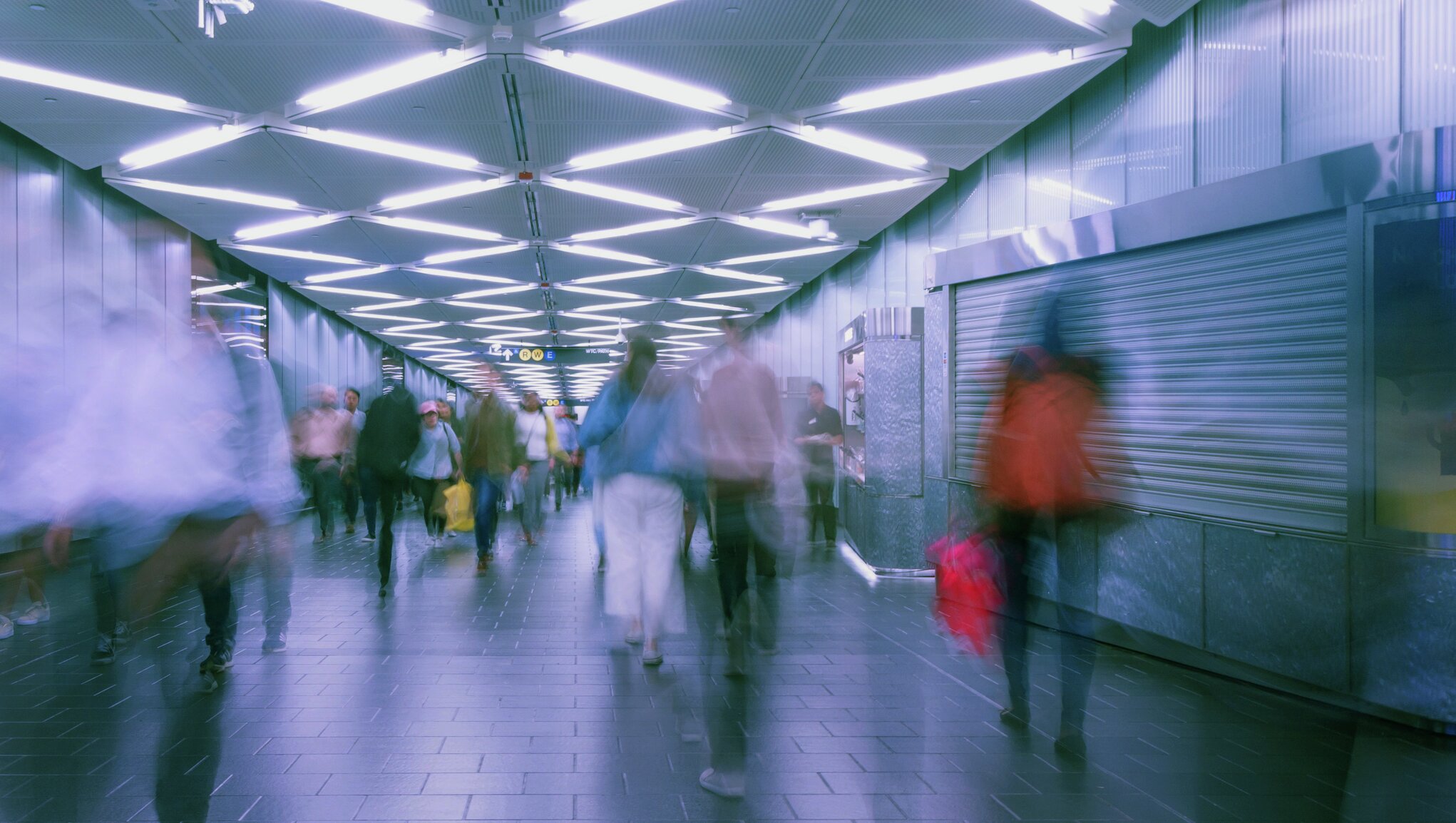 people on subway platform, a blurry image to demonstrate tired eyes.
