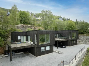 Bilde av moderne tomannsbolig i Morvik i Bergen. Boligen er arkitekttegnet med MøreRoyal Black kledning og grå terrassebord