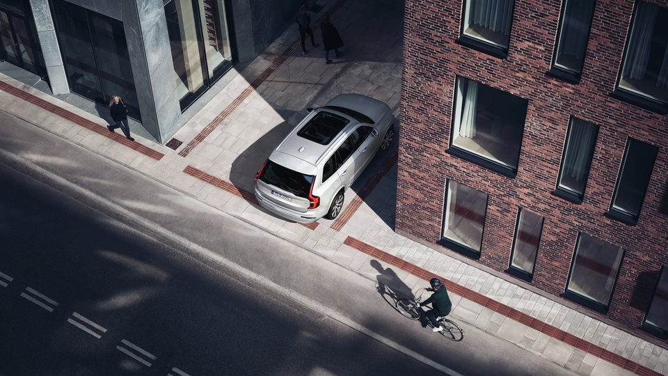 Volvo backar runt gatuhörn medan City Safety systemet upptäcker närmande cyklist och fotgängare