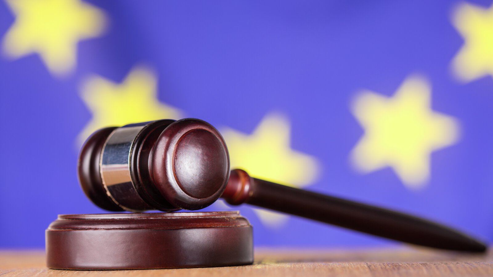 Jugde's gavel with the EU flag in the background
