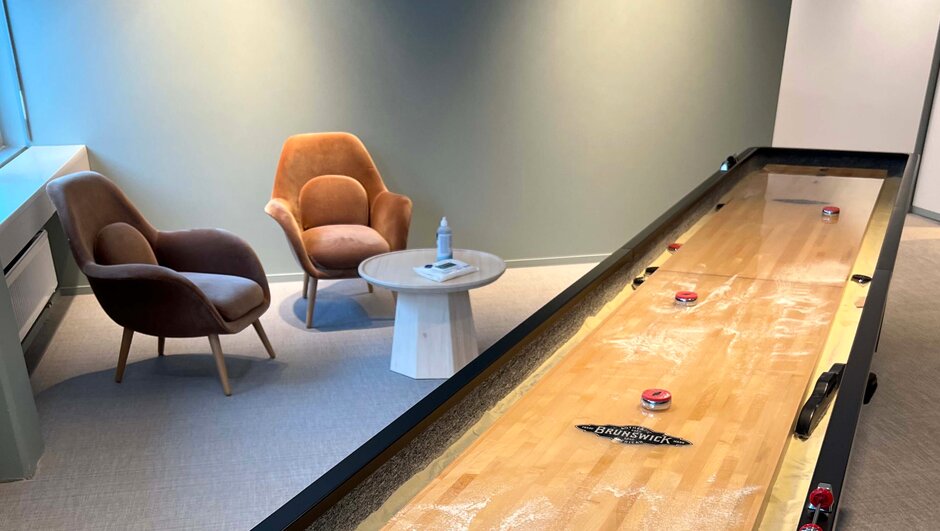 Two comfy armchairs next to a shuffleboard game