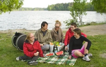 Vennegjeng på piknik, rullestol i bakgrunnen