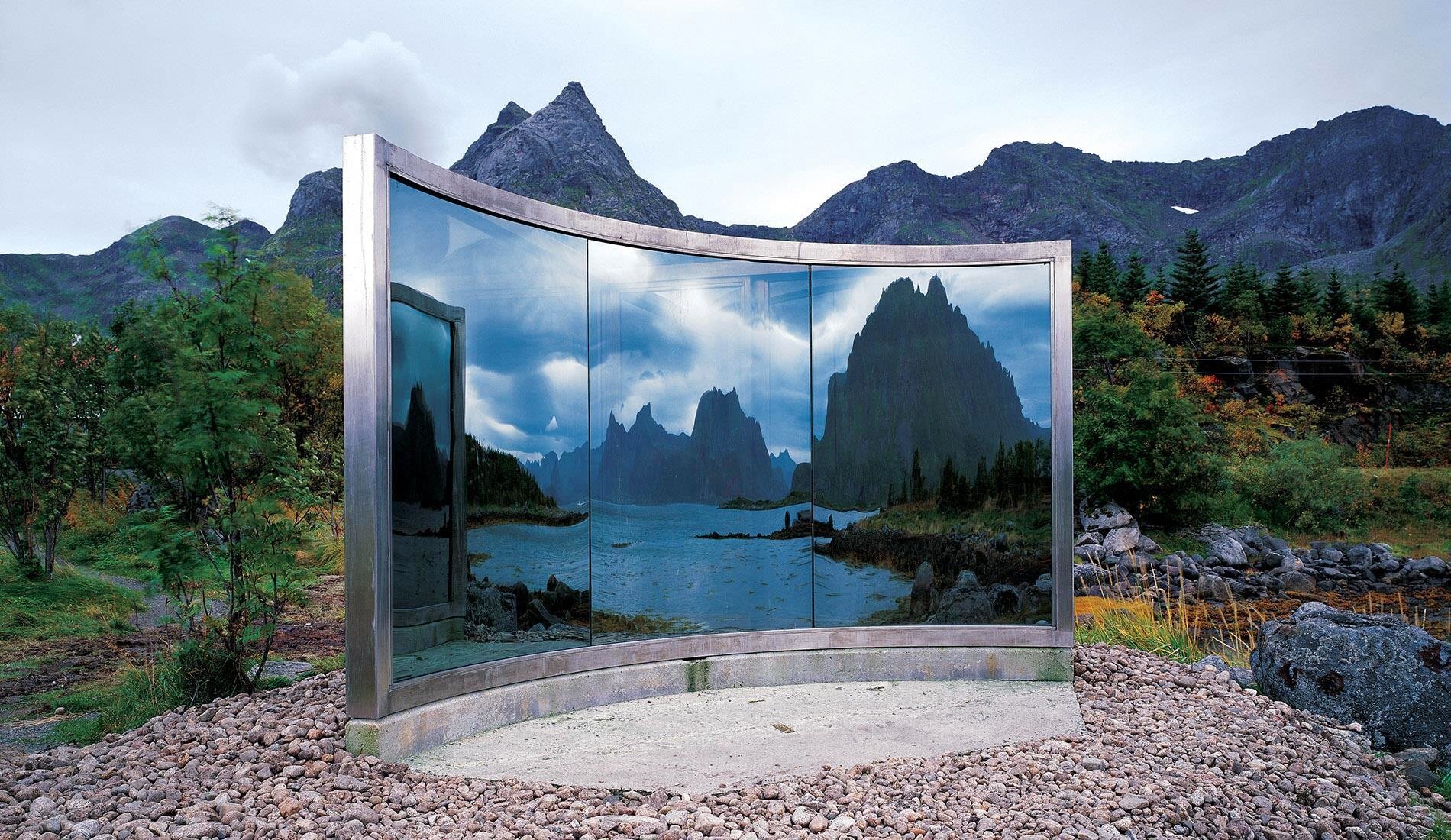 Speil- og metallskulptur i Nordland, med trær og fjell i bakgrunnen.