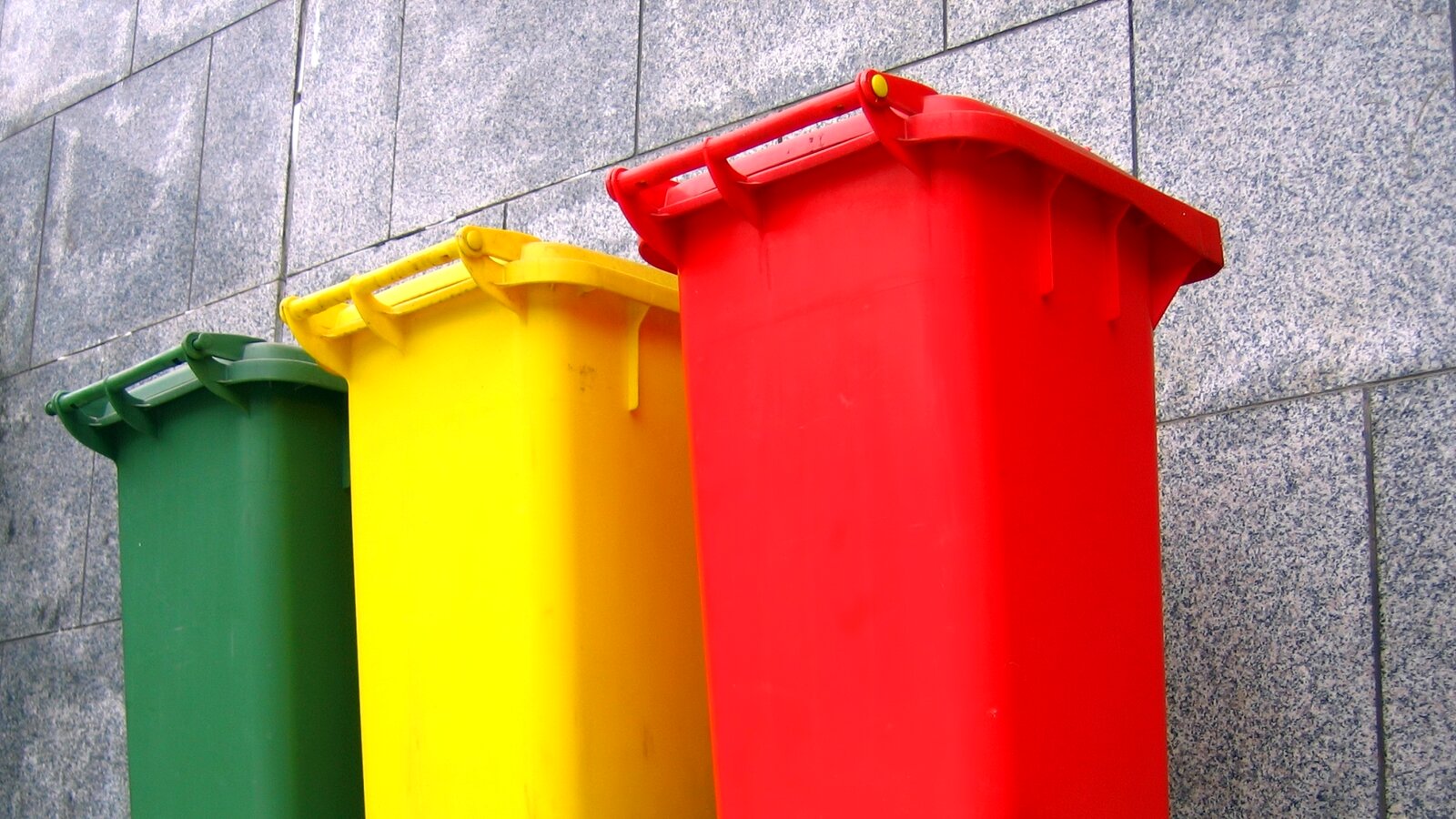 Tre avfallsdunker i fargene rød, gul og grønn