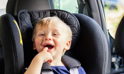 Pojke i bakåtvänd bilbarnstol