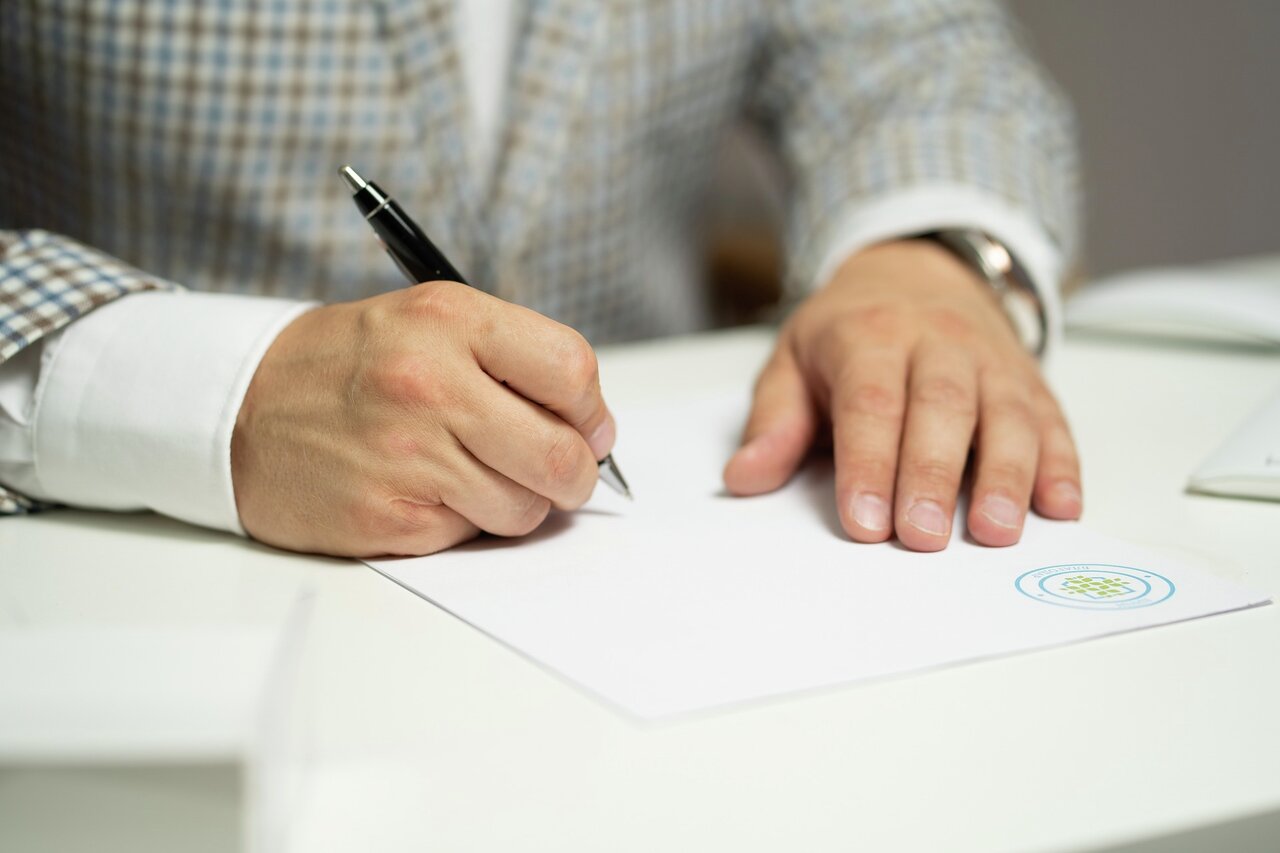 Person skriver under på kontrakt