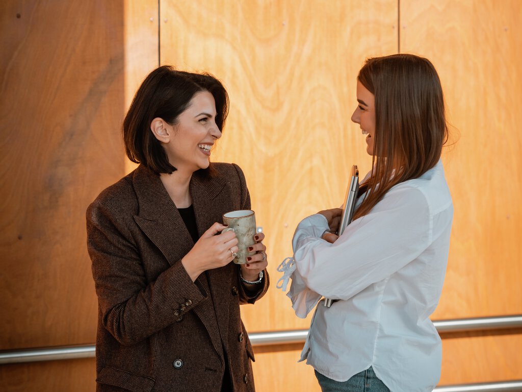 To kvinnelige kollegaer i samtale utendørs 