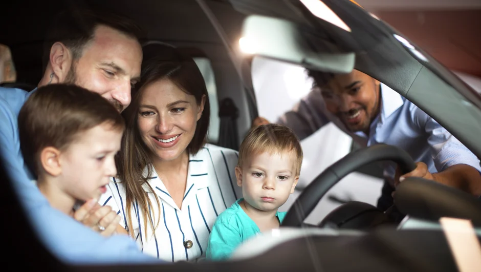 Perhe tutustuu auton ohjaamossa autoon