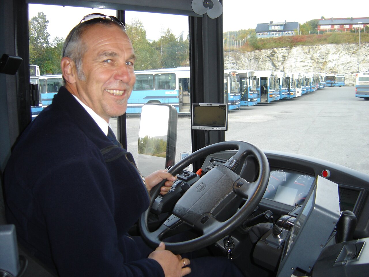 Etter først å ha vært gjennom et salg, og så en fusjon, heter busselskapet Tore Karlsen jobber i, nå Cominor. Men på jakka står det fremdeles Tromsbuss.