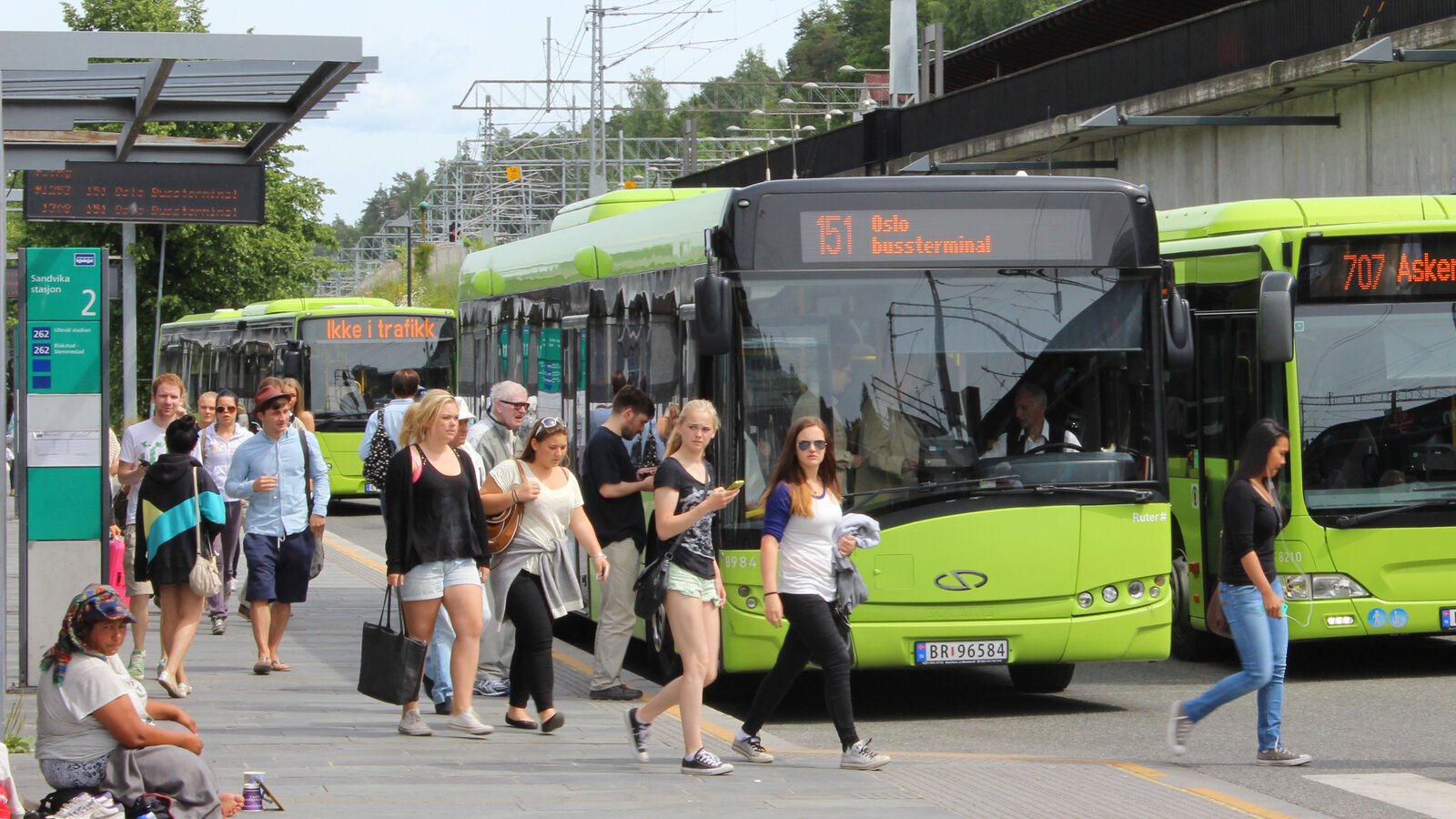 mennesker som gåt ombord i grønne busser ved Sandvika stasjon