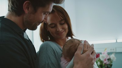 Mies ja nainen syleilevät vauvaa