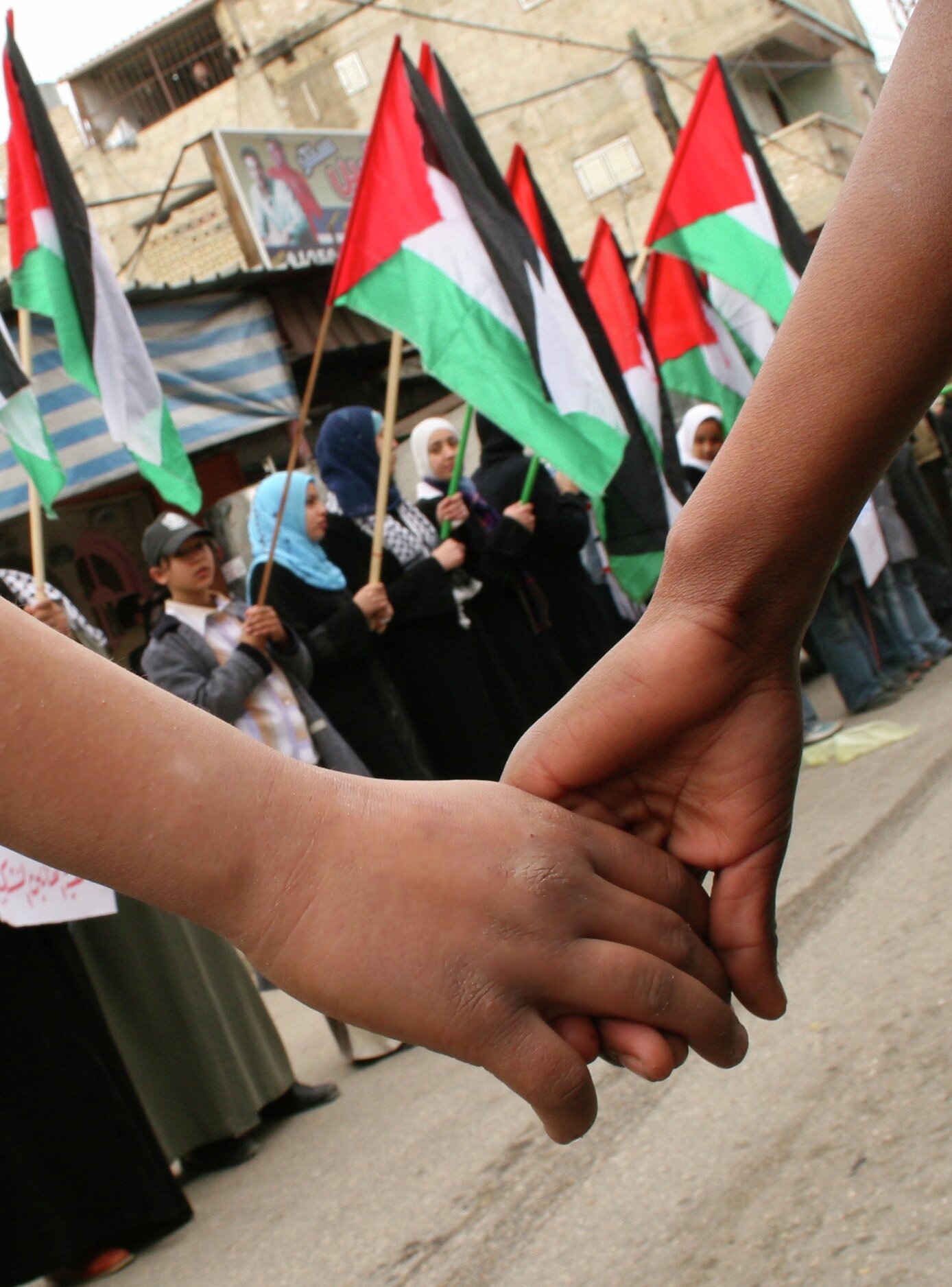 Picture is taken in March 2006. Holding hands in front of a line up with palestinian flags. Leier hverandre foran oppstilte palestinske flagg