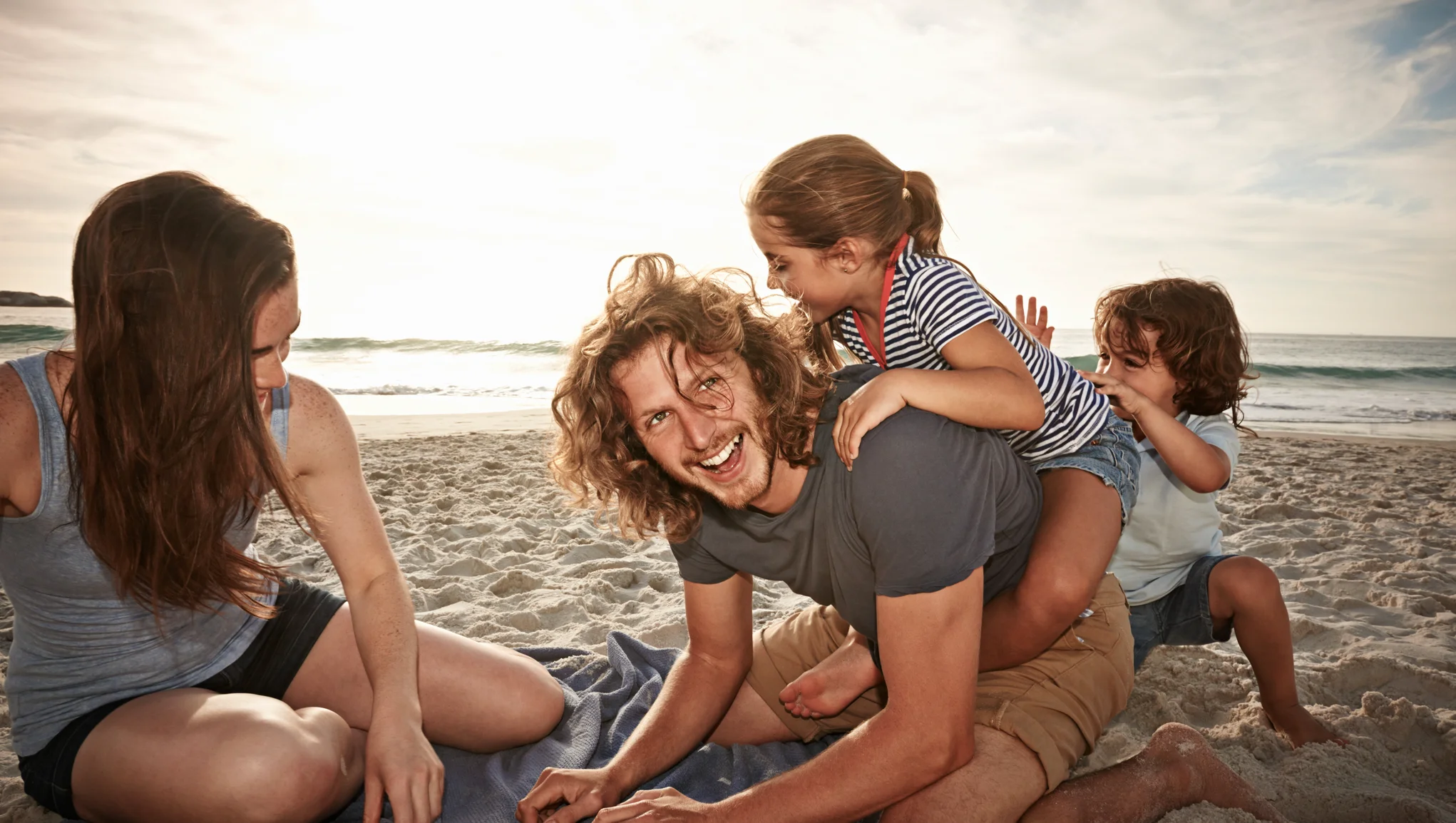 Perhe leikkii rannalla