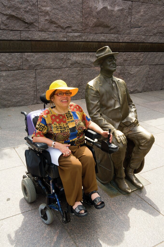 Judy Heumann ved sidan av statua av Franklin D. Roosevelt i Washington i USA. 
