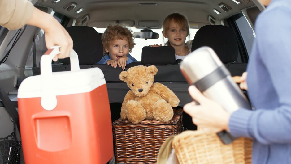 Kids sitting at the backseat of a car.